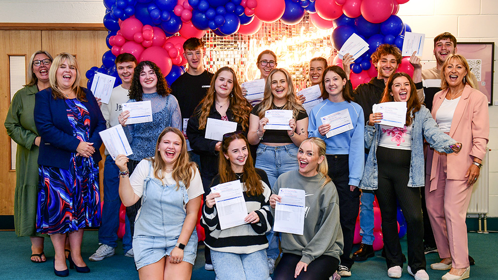 Group of happy students holding their results