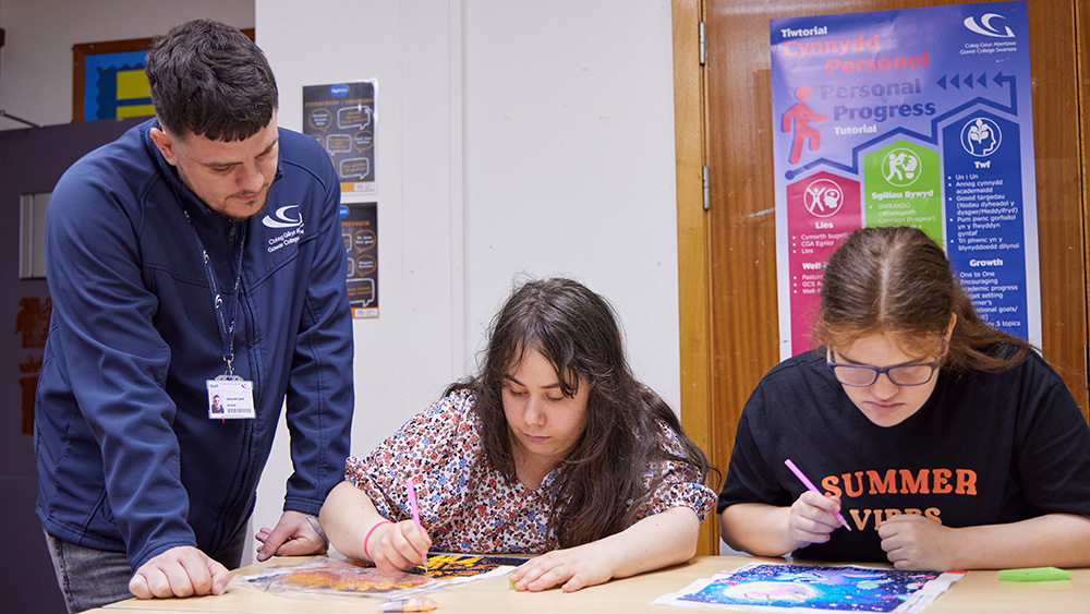 Teacher helping two students with their work
