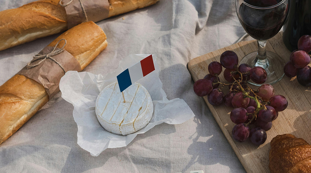 French cheese with french flag next to grapes and baguette