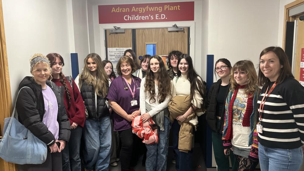 Myfyriwr celf yn rhoi golwg lliwgar newydd i uned y plant