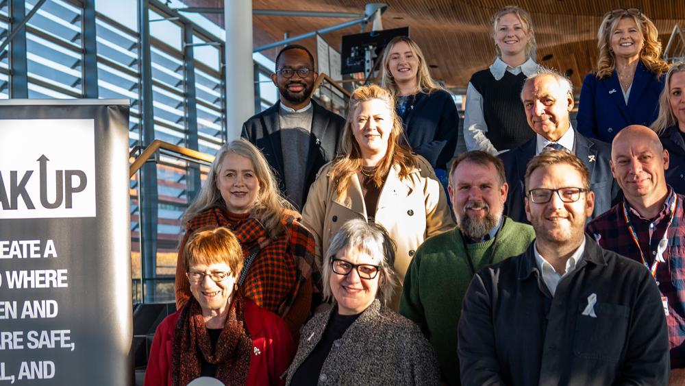 Sarah King and Lorraine Evans with group of people coming together outside the Senedd to mark White Ribbon Day