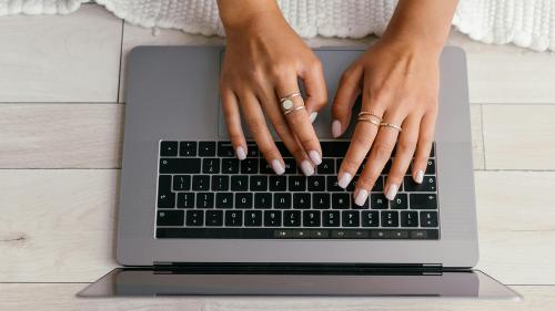 Hands typing on laptop keyboard