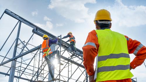 Construction manager watching workers at height