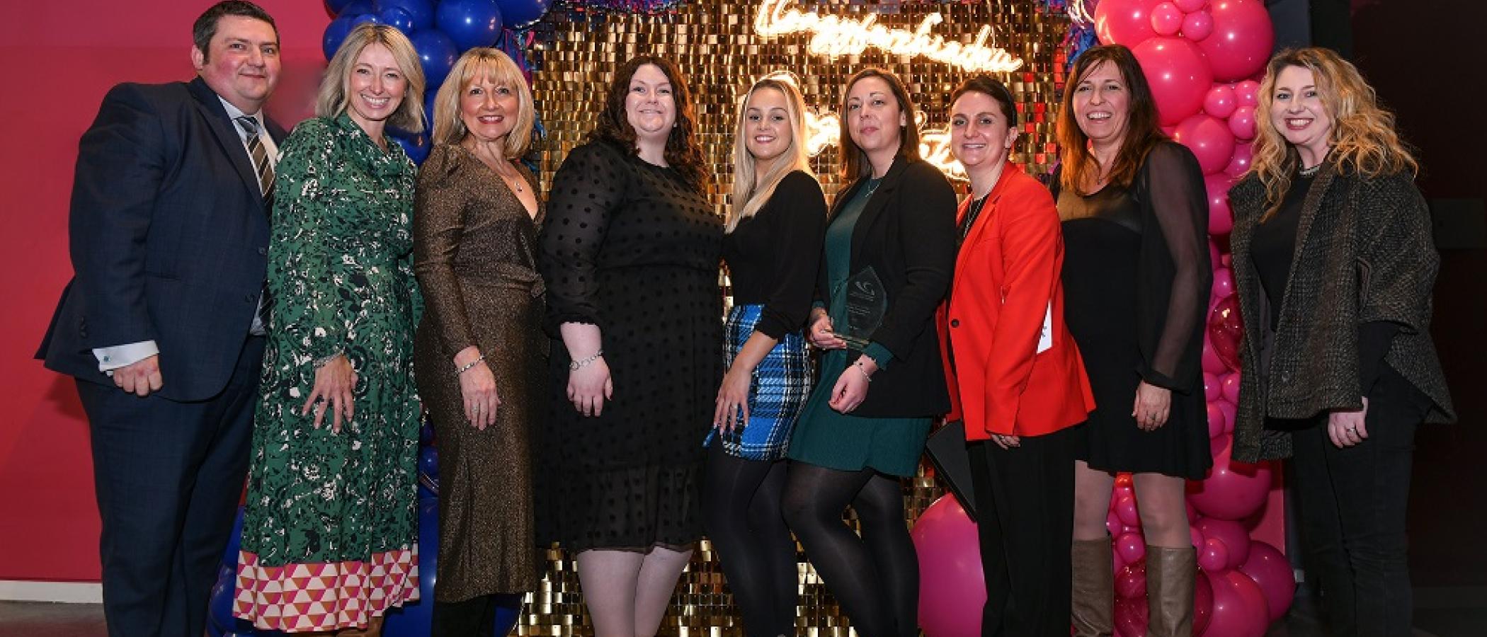 Housing team posing in front of balloons backdrop at Apprenticeship Awards 2023