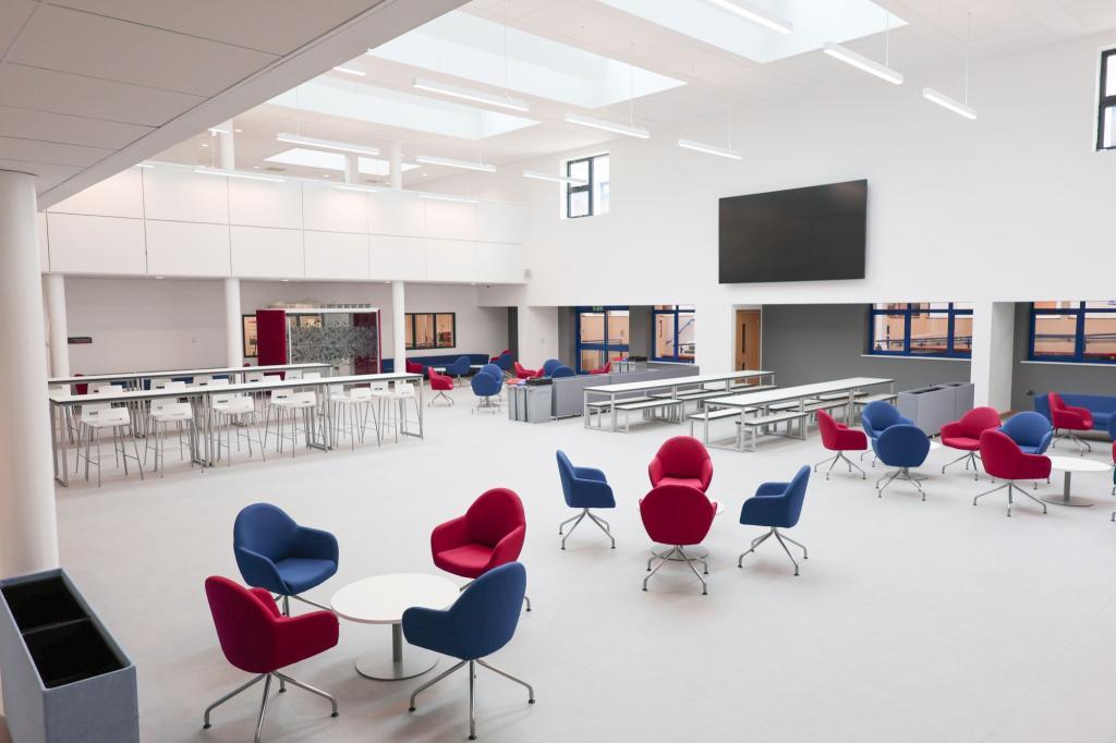 Photograph of the new social space in Gorseinon. A big open plan area with new seating and a high roof with skylights