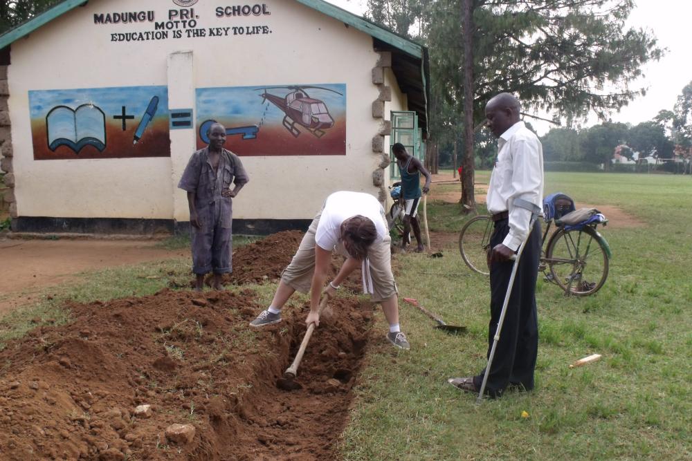 A Kenya project student helps dig the foundations for the new school library